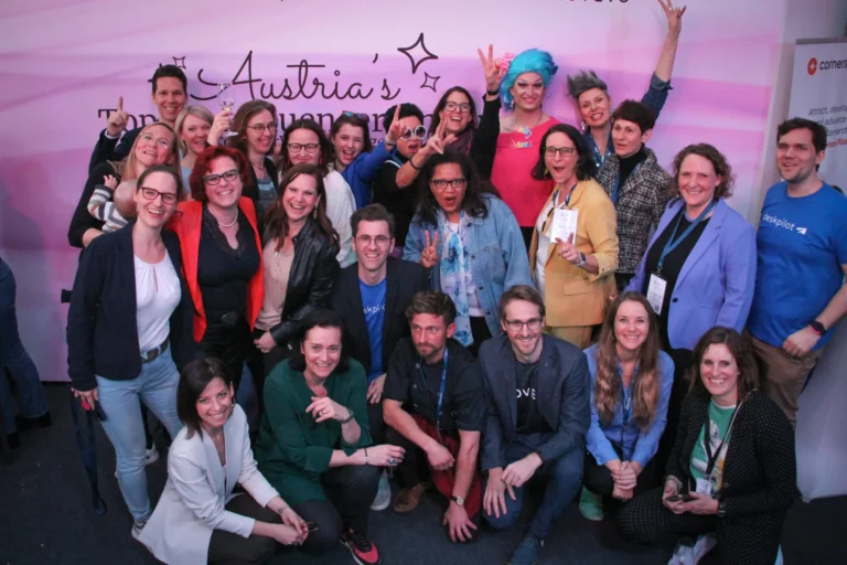 Eine Gruppe von Menschen, HR Expert*innen, jubeln vor der Leinwand Austria’s Top HR Influencer*innen.