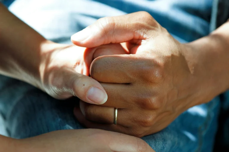 Zwei Hände halten sich fest – Symbol für Unterstützung und Fürsorge bei der Pflege von Angehörigen