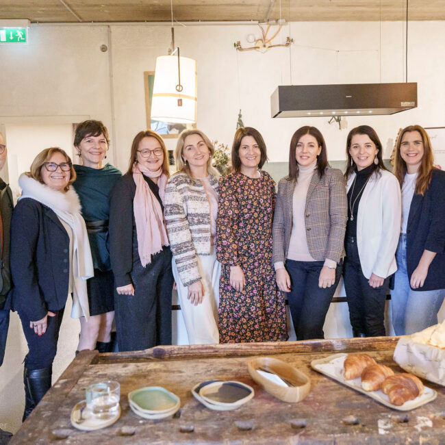 Gruppe von Teilnehmenden beim HR Role Model Brunch in modernem Loft mit gedecktem Tisch und Gebäck
